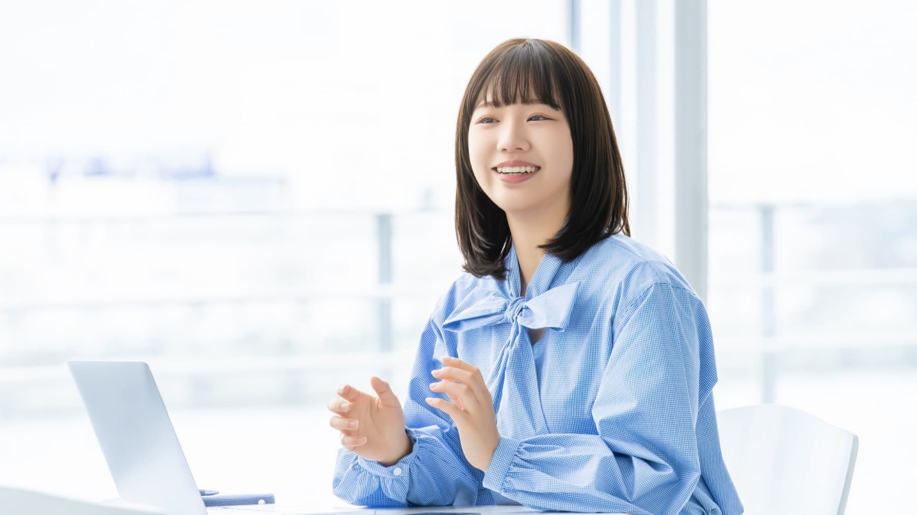 パソコンの前で笑顔で話す社員