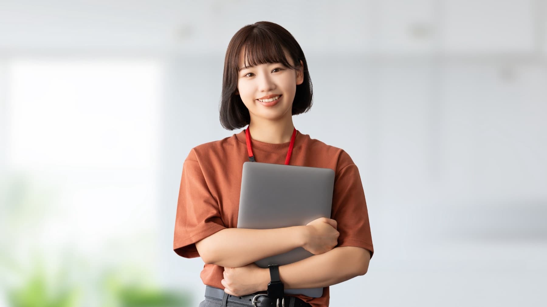 ノートパソコンを抱えて笑顔の社員